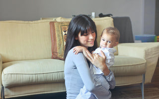 World Breastfeeding Week, mom holding her baby, sitting on the couch