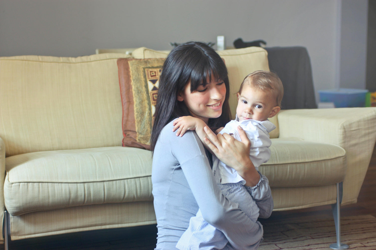 World Breastfeeding Week, mom holding her baby, sitting on the couch